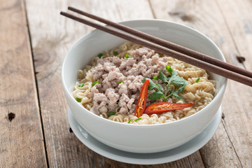 Instant noodles with minced pork in white bowl.