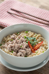 Instant noodles with minced pork in white bowl.