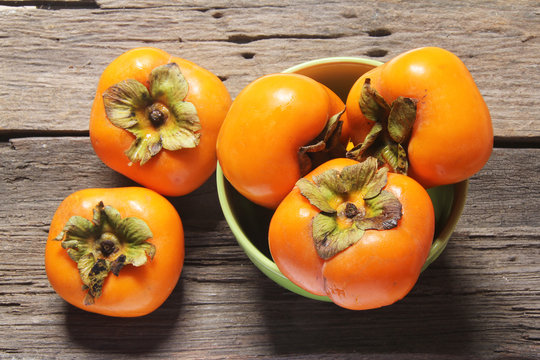 Fresh ripe persimmon on a wooden