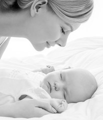 Young mother and her baby, sleeping in bed. Mother and baby. Hap