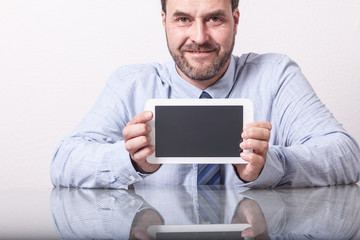 Business man on office desk, showing tablet computer with empty