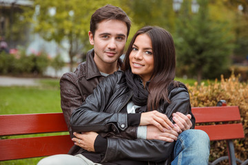 Naklejka premium Couple sitting on the bench outdoors