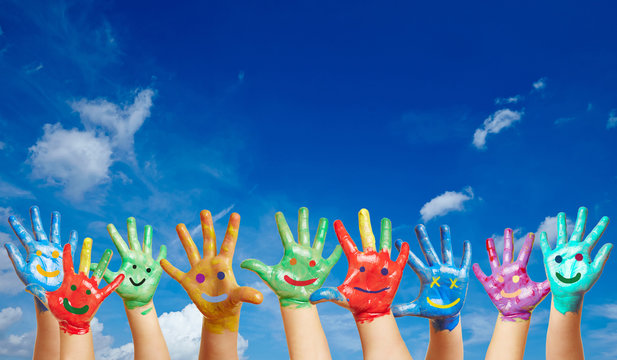 Viele bunte Kinderh&auml;nde vor Himmel
