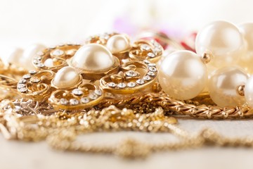 shiny gold and silver jewelery on white table