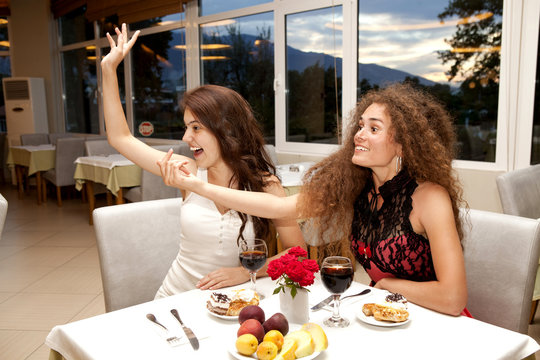 Two pretty girls having dinner in a restaurant