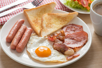 English breakfast with coffee on wood table.