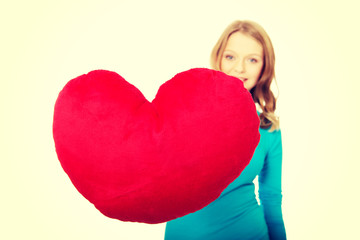 Young woman with heart shaped pillow