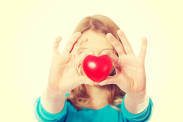 Young woman holding heart model
