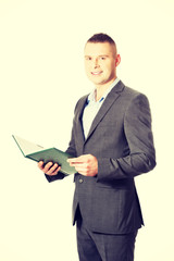 Obraz na płótnie Canvas Young businessman reading his note book