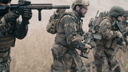 Slow motion of armed soldiers running forward to attack - Powered by Adobe