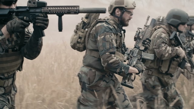 Slow motion of armed soldiers running forward to attack 