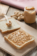 Peanut butter sandwich on wood cutting board.
