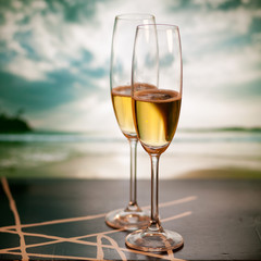 Champagne glasses on tropical beach at sunset - exotic New Year