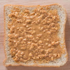 Peanut butter sandwich on wood background. Top view.