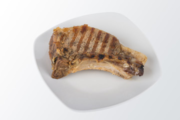 Hot grilled meat on white plate on gradient background