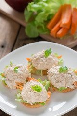 Crackers with tuna salad on white palte.