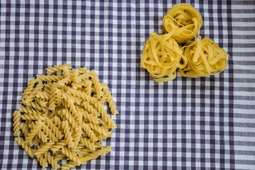 Different noodles on a checkered tablecloth. Top