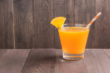 Fototapeta na wymiar Glass of fresh orange juice on wooden table