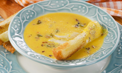 Bowl of pumpkin soup with a crouton.