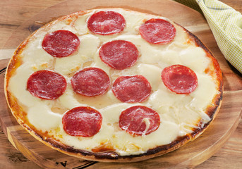 Pizza pepperoni served on  wooden board.