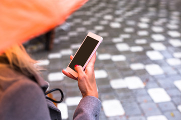 Young woman texting sms in beautiful autumn park