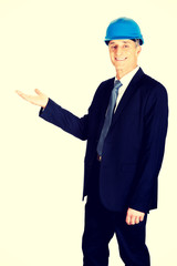 Businessman in hard hat presenting something