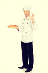 Chef baker with italian pizza showing perfect sign