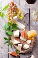 Grape, cheese, figs and honey with a glasses wine. 