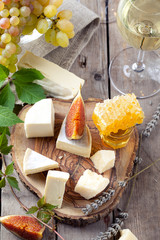 Grape, cheese, figs and honey with a glasses wine. 
