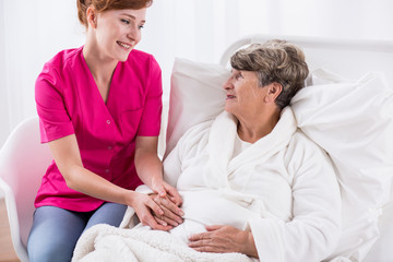 Obraz premium Happy carer assisting senior woman