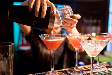 De meisjesbarman bereidt een cocktail voor in de nachtclub