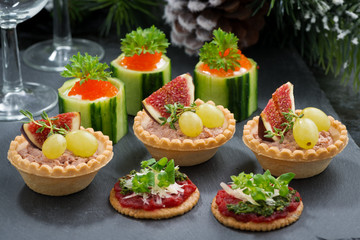 Set of festive Christmas mini appetizers on dark background