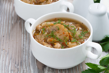 soup with cabbage, mushrooms and chickpeas on wooden background