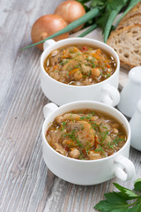 soup with cabbage, mushrooms and chickpeas on wooden background