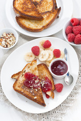 sweet breakfast - crispy toasts with raspberries, banana and jam
