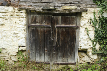 old worn out wooden door with rusty metal hinges