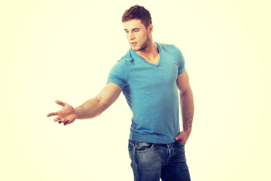 Handsome young man pointing down.