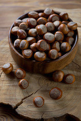 Closeup of a wooden bowl with hazelnuts, selective focus