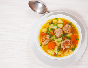 Soup with meatballs, farfalle pasta and vegetables