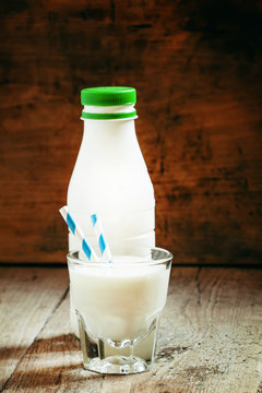 Milk yogurt in a glass with a straw and in a white bottle, selec