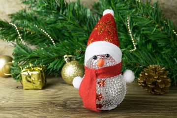 Christmas snowman toy and Christmas decorations on old wooden ba