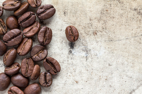 Roasted coffee beans on dirty canvas