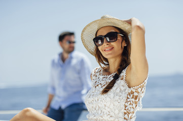 Attractive couple on a yacht enjoy bright sunny day on vacation