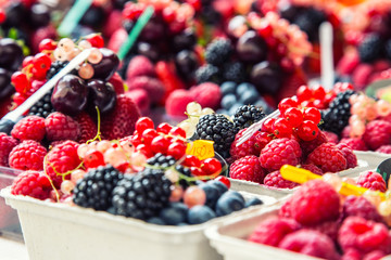 Berry fruits at a marketplace Blueberries, raspberries, strawberries, cherries Forest fruits. Gardening ,agriculture,harvest and forest concept.