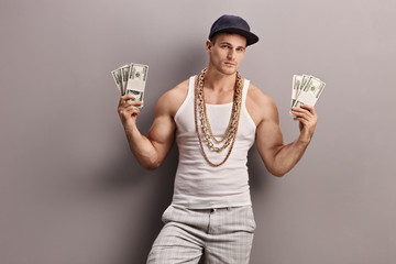 Young male rapper holding money - obrazy, fototapety, plakaty