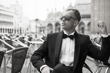 Black and white photo of confident man in tuxedo