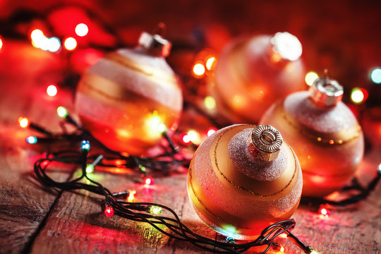 Golden Christmas tree balls and colored Christmas lights on an o