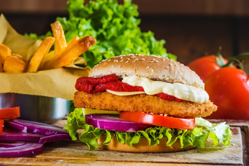 Juicy and delicious looking chicken burger with fried potatoes