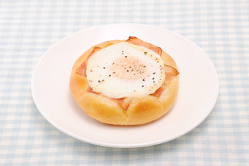 お皿にのせた ベーコンエッグパン 総菜パン テーブルクロス