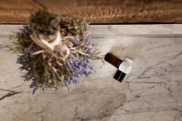 Ätherische Öle liegen unter einem Bund getrockneten Lavendel